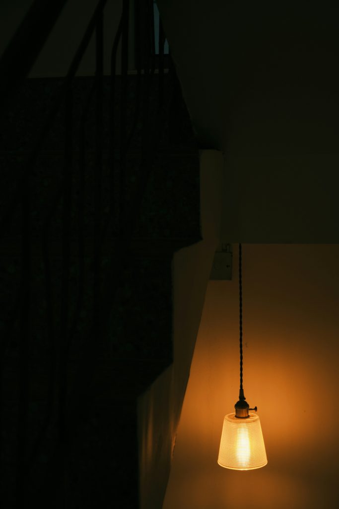 A low hanging light fixture with a warm bulb