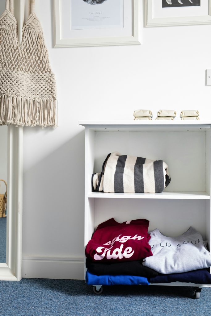 White open cabinet with folded up clothes